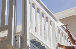Painter decorators in Bournemouth. Interior spraying and exterior spraying. Man spraying banister with paint.